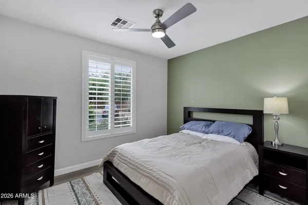 a bedroom with a bed a dresser and a window