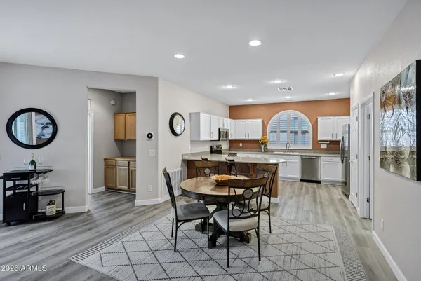 a view of a dining room and kitchen with furniture a rug and wooden floor
