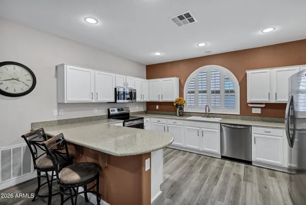 a kitchen with a table chairs sink and cabinets