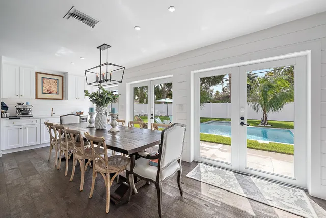 a view of a dining room with furniture a livingroom and chandelier