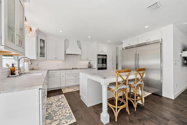 a kitchen with white cabinets and stainless steel appliances