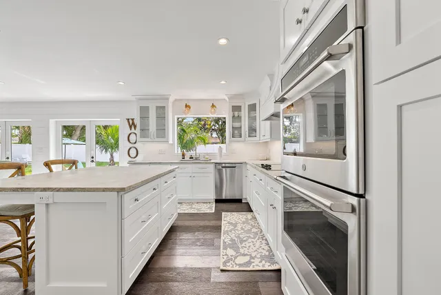 a kitchen with granite countertop a sink stainless steel appliances and cabinets