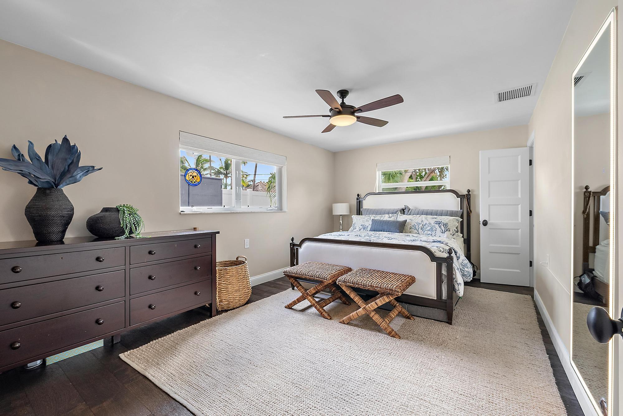 8 Windsor Road West Jupiter, FL 33469 - Photo 17 of 32 a bedroom with a bed and a chandelier