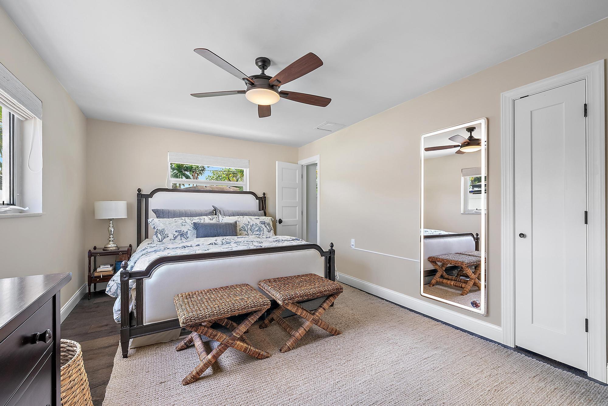 8 Windsor Road West Jupiter, FL 33469 - Photo 18 of 32 a bedroom with a bed and a chandelier