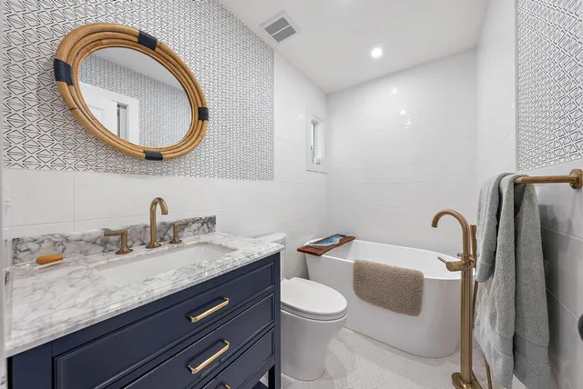 a bathroom with a granite countertop toilet sink and mirror