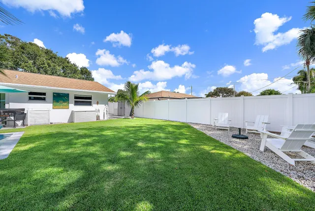a view of a house with backyard and sitting area