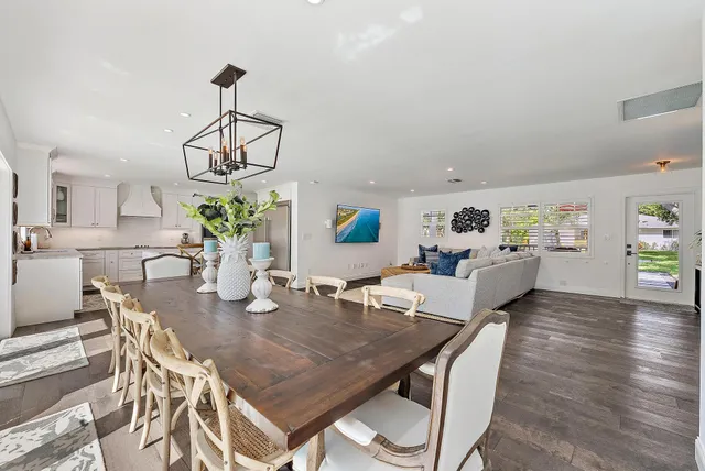 a view of a dining room and livingroom with furniture wooden floor a chandelier