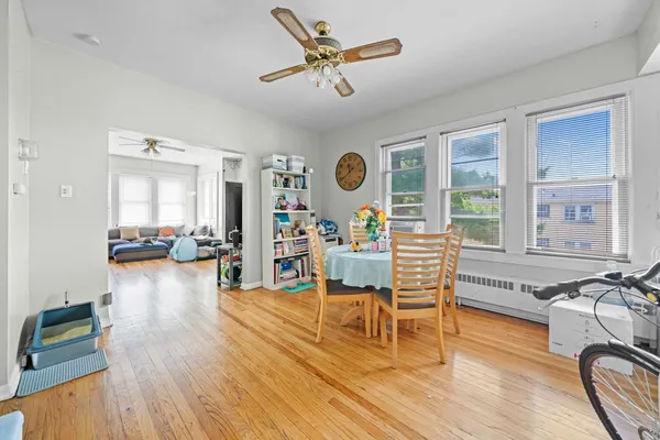 a living room with furniture and wooden floor next to a large window