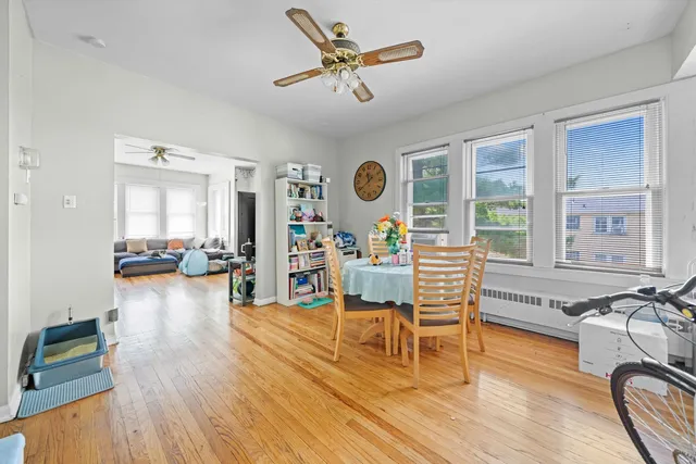 a living room with furniture and wooden floor next to a large window