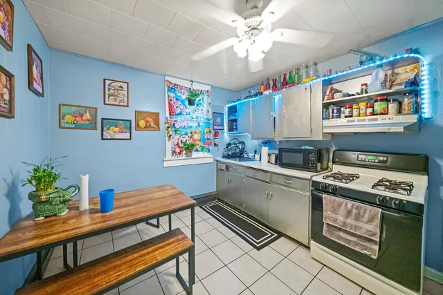 a kitchen with stainless steel appliances a stove a chimney a sink and cabinets
