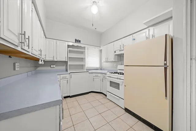 a kitchen with white cabinets and white appliances