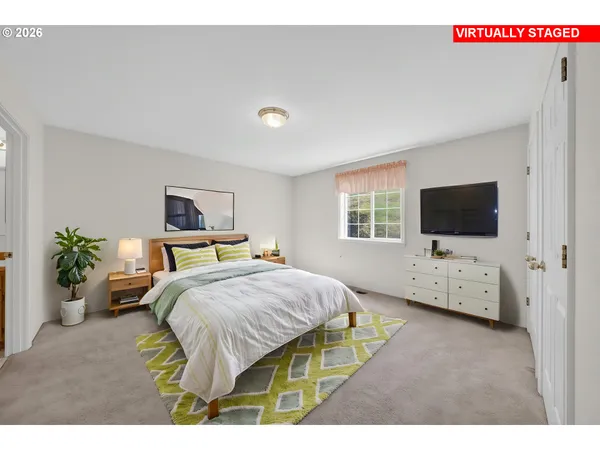 a bedroom with a bed a window and flat screen tv