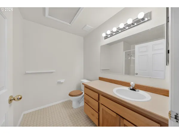 a bathroom with a sink a toilet a mirror and shower