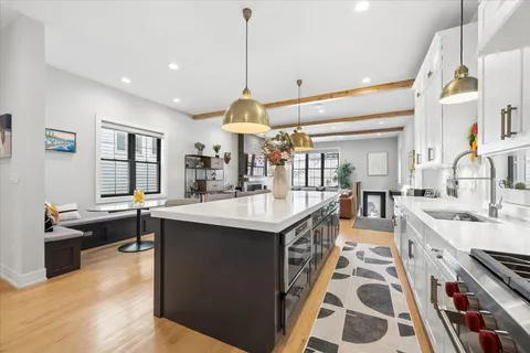 a kitchen with kitchen island granite countertop a sink cabinets and stainless steel appliances