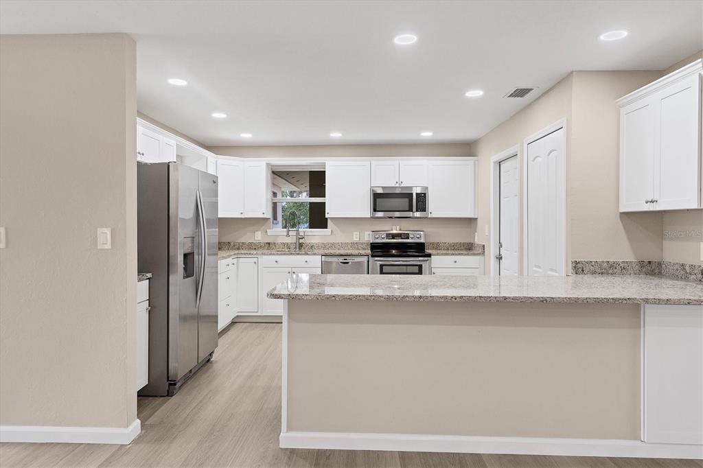 76 Caddy Road Rotonda West, FL 33947 - Photo 12 of 62 a kitchen with stainless steel appliances a refrigerator and a stove top oven
