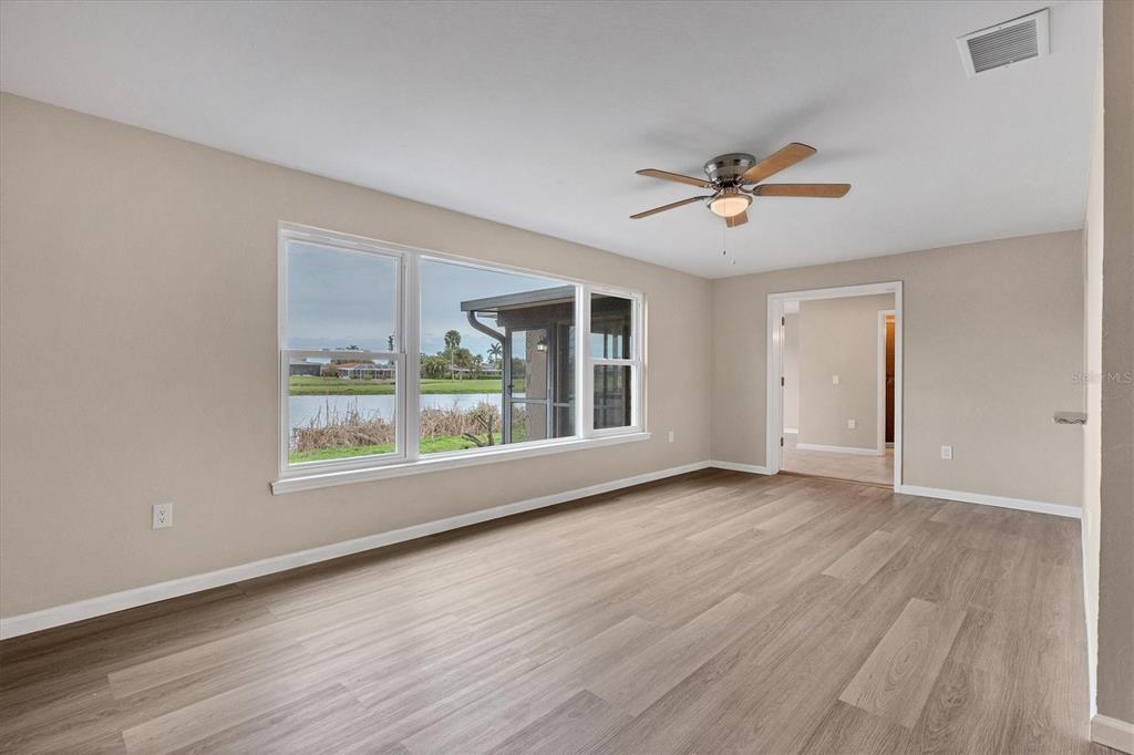 76 Caddy Road Rotonda West, FL 33947 - Photo 18 of 62 an empty room with wooden floor and windows