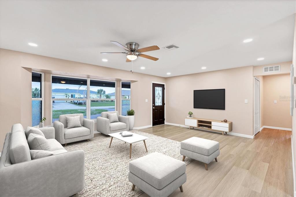 76 Caddy Road Rotonda West, FL 33947 - Photo 2 of 62 a living room with furniture and a flat screen tv