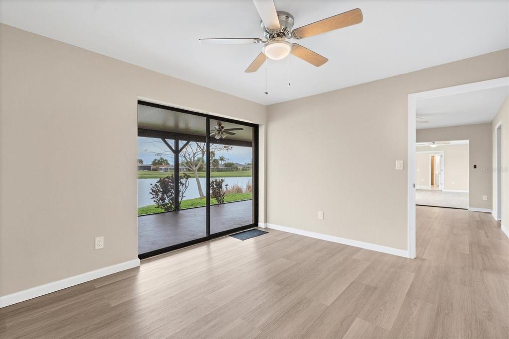 76 Caddy Road Rotonda West, FL 33947 - Photo 21 of 62 an empty room with wooden floor and windows