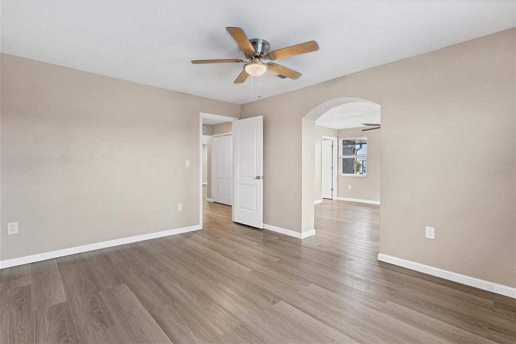 76 Caddy Road Rotonda West, FL 33947 - Photo 23 of 62 a view of an empty room with wooden floor and a ceiling fan