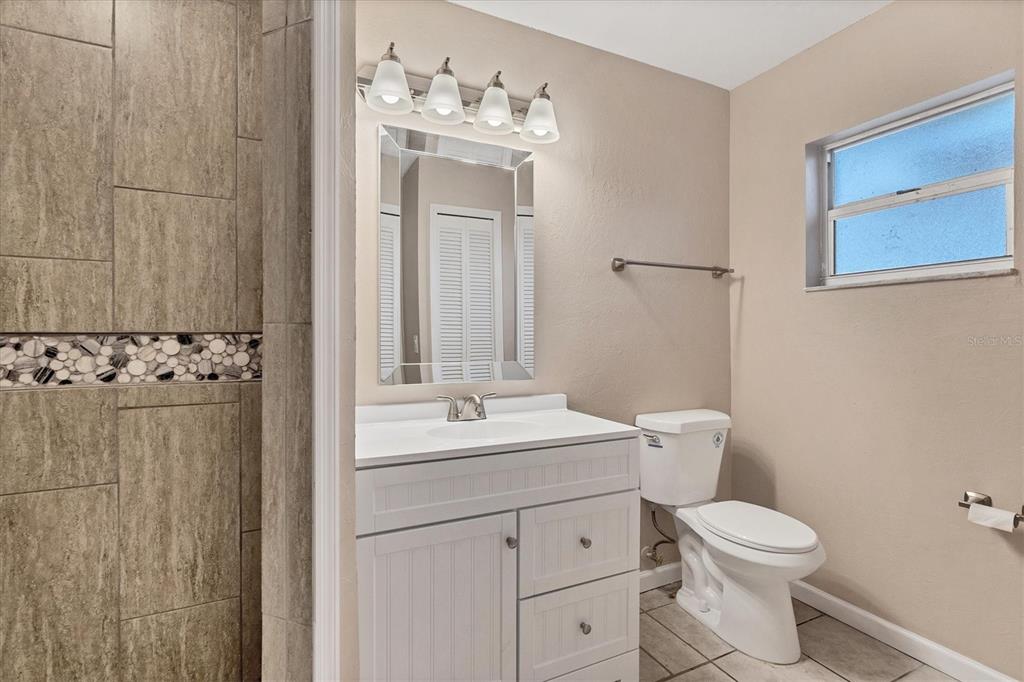 76 Caddy Road Rotonda West, FL 33947 - Photo 32 of 62 a bathroom with a toilet a sink and mirror