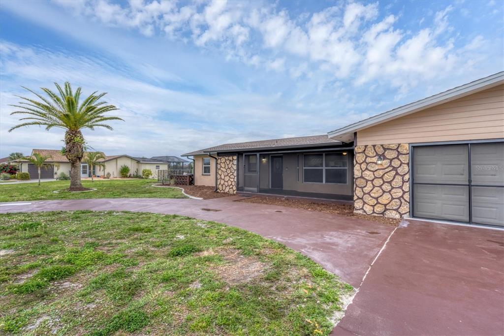 76 Caddy Road Rotonda West, FL 33947 - Photo 41 of 62 a front view of a house with a garden and yard