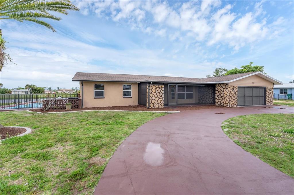 76 Caddy Road Rotonda West, FL 33947 - Photo 62 of 62 a front view of a house with garden