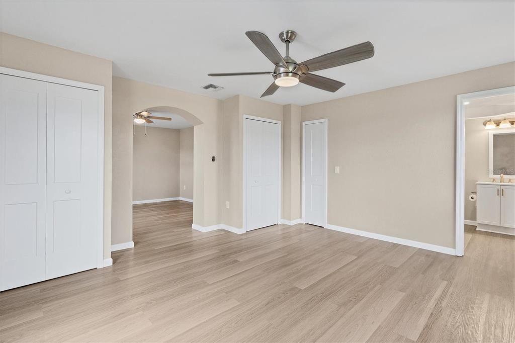 76 Caddy Road Rotonda West, FL 33947 - Photo 9 of 62 an empty room with wooden floor fan and windows
