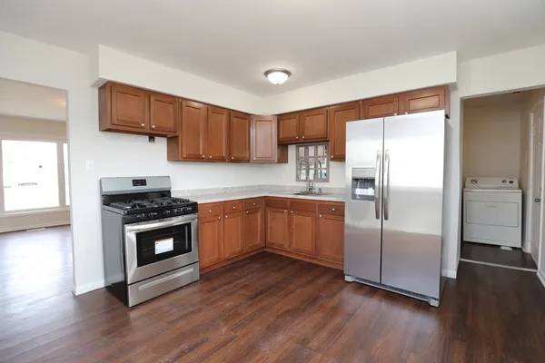 a kitchen with wooden floors and stainless steel appliances