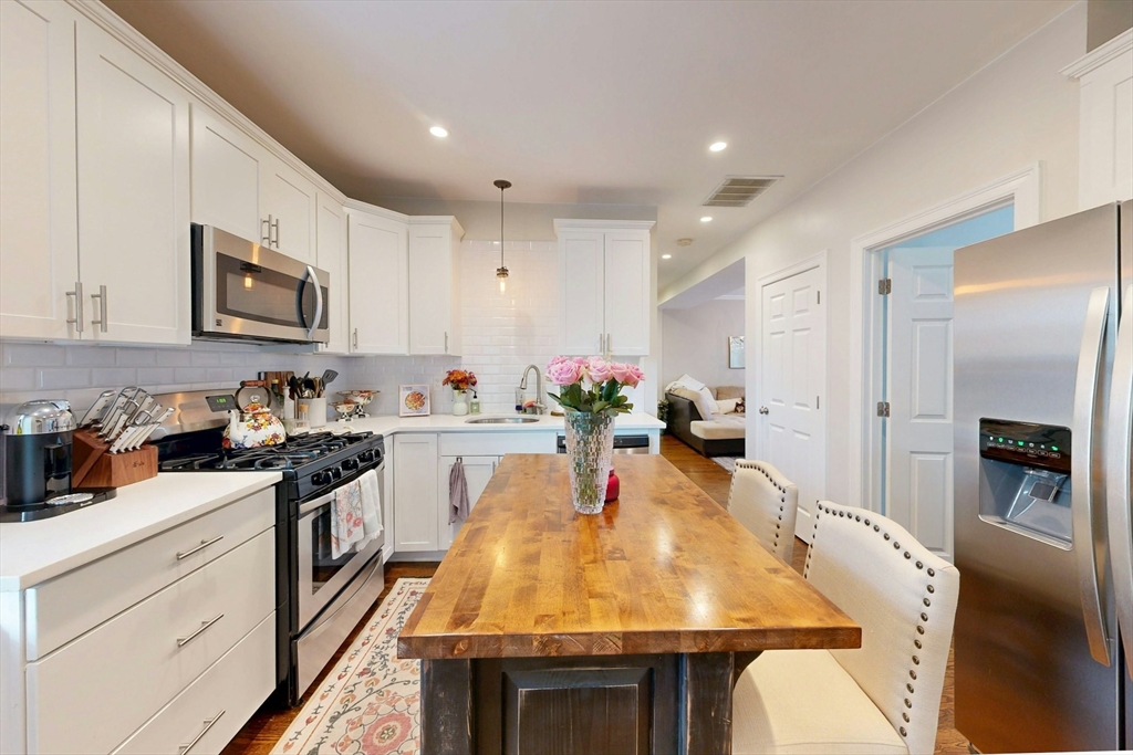 38 Pearl Street, Unit 3 Everett, MA 02149 - Photo 5 of 14 a large kitchen with stainless steel appliances granite countertop a stove a sink dishwasher and a refrigerator with wooden floor