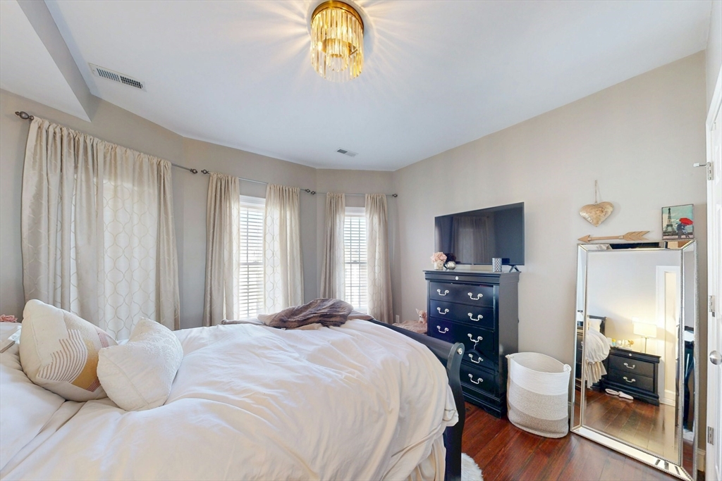 38 Pearl Street, Unit 3 Everett, MA 02149 - Photo 7 of 14 a bedroom with a bed and a chandelier
