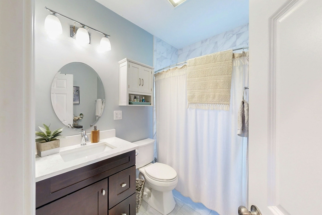 38 Pearl Street, Unit 3 Everett, MA 02149 - Photo 8 of 14 a bathroom with a toilet a sink and a mirror