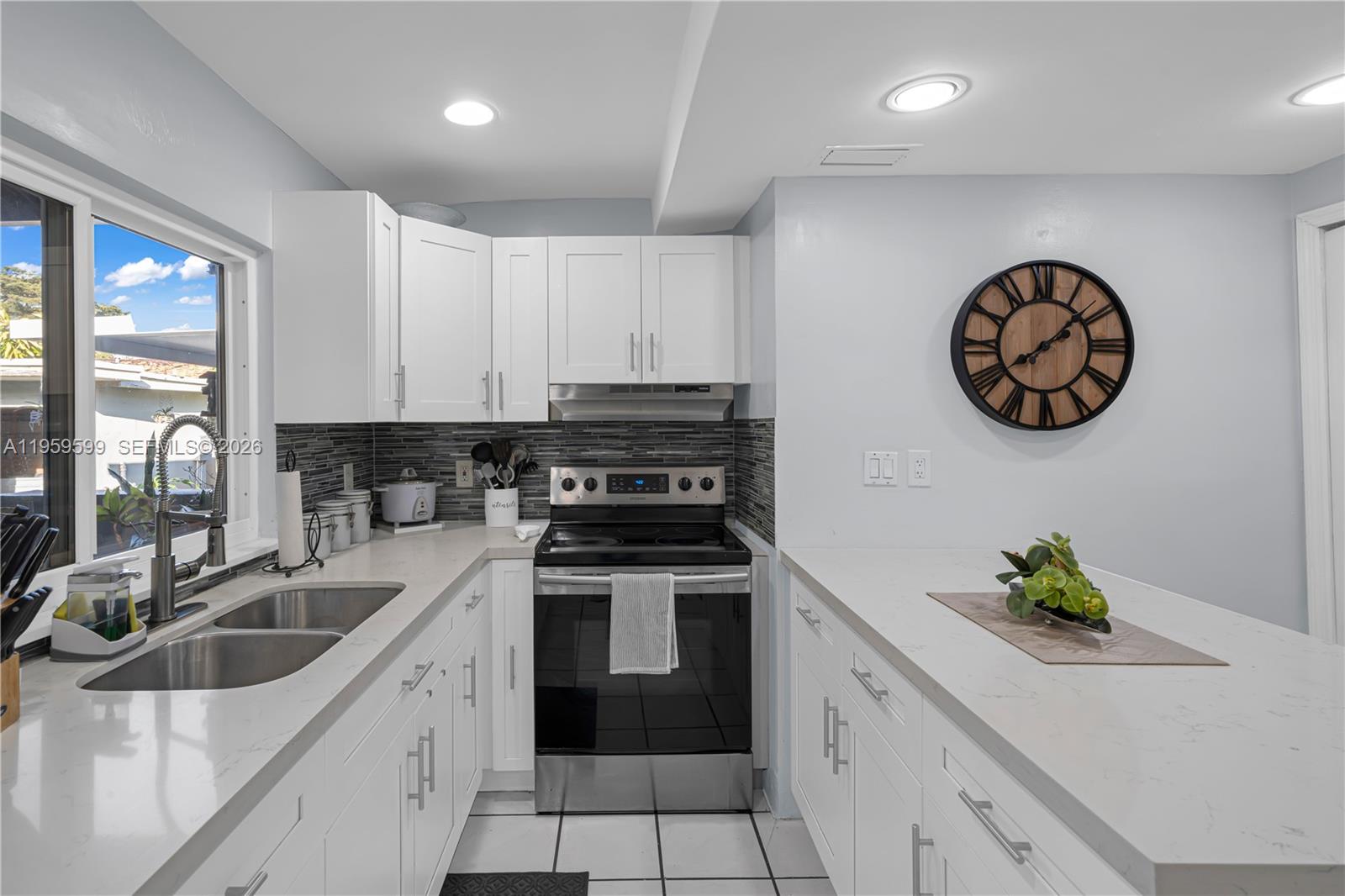 11021 Southwest 4th Street Sweetwater, FL 33174 - Photo 10 of 43 a kitchen with granite countertop a sink a stove and cabinets