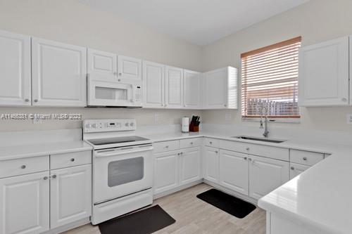 13234 Southwest 128th Path Miami, FL 33186 - Photo 11 of 38 a kitchen with cabinets appliances a sink and a window