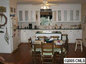 2203 Braswell-Rushing Road Monroe, NC 28110 - Photo 4 of 8 a kitchen with stainless steel appliances granite countertop a stove top oven a sink a dining table and chairs