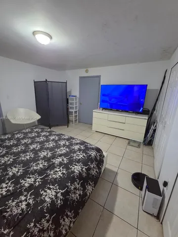 a bedroom with a bed and a dresser with mirror