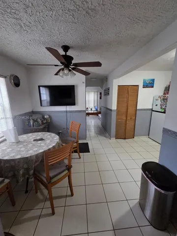 a living room with furniture a flat screen tv and kitchen view