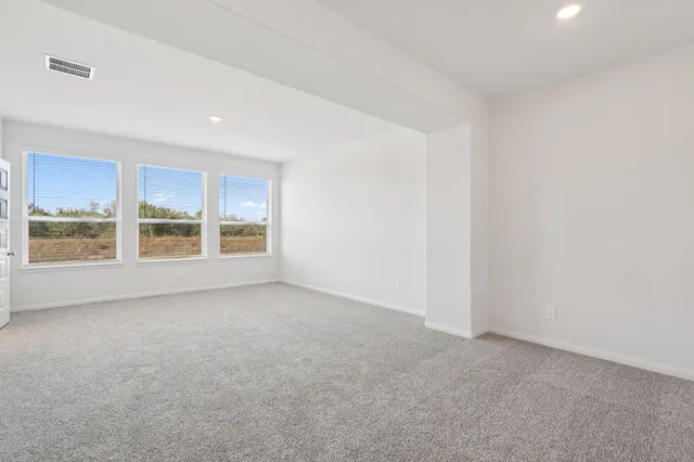 a spacious bedroom with a bed and a flat screen television