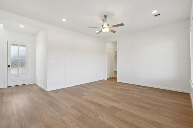 a view of an empty room with wooden floor