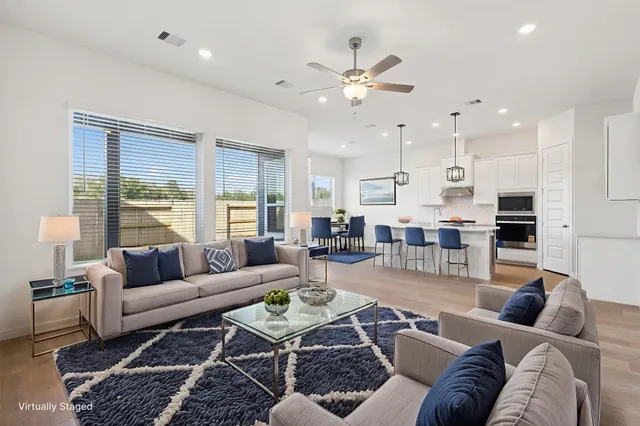 a living room with furniture kitchen and a large window