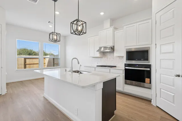 a kitchen with a sink and a stove top oven