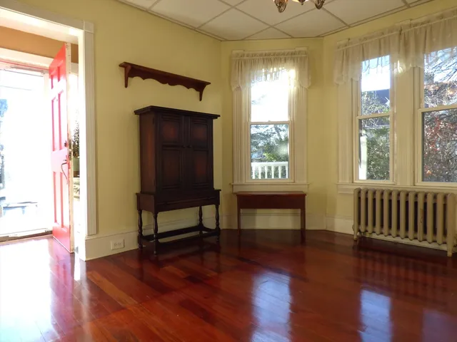 a view of a bedroom with furniture window and wooden floor
