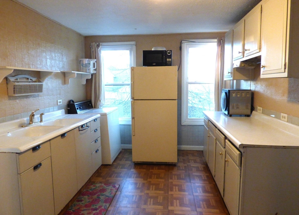 298 Main Street Springfield, MA 01151 - Photo 28 of 40 a kitchen with a sink a refrigerator a stove a washer dryer and a window