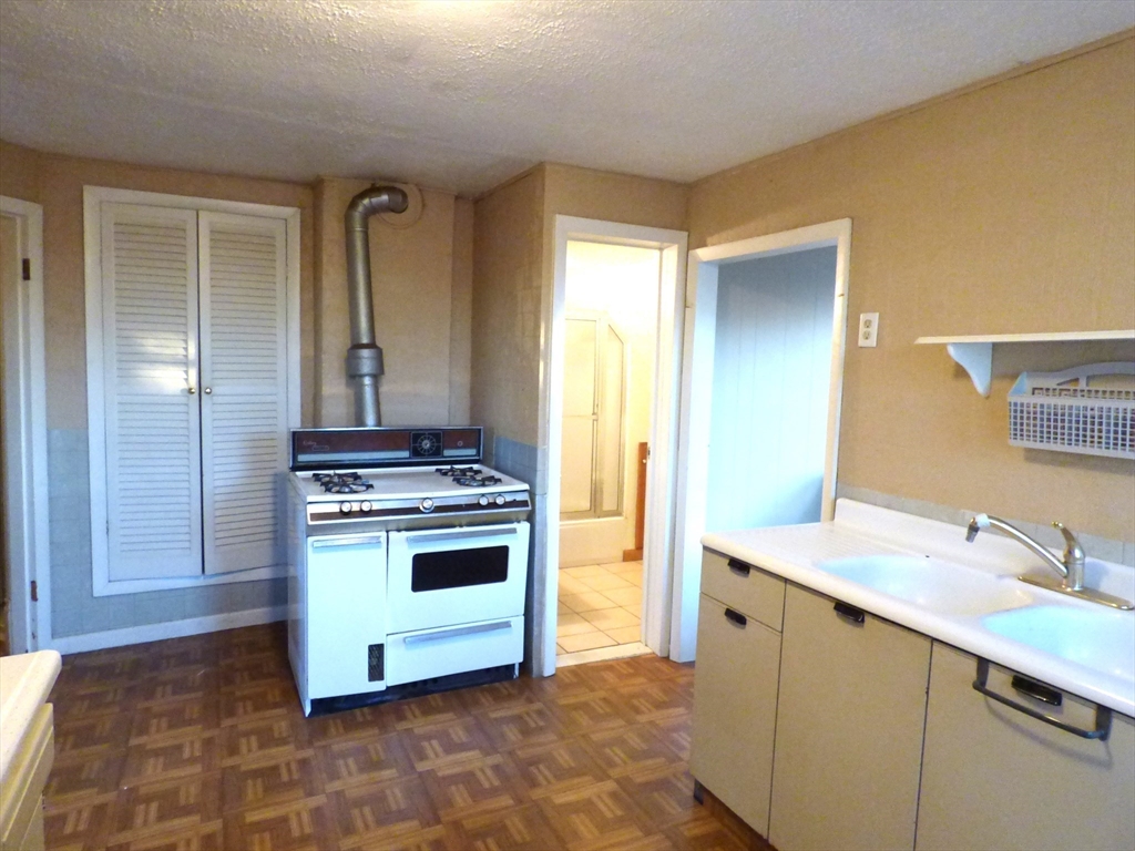 298 Main Street Springfield, MA 01151 - Photo 30 of 40 a kitchen with a stove cabinets and sink