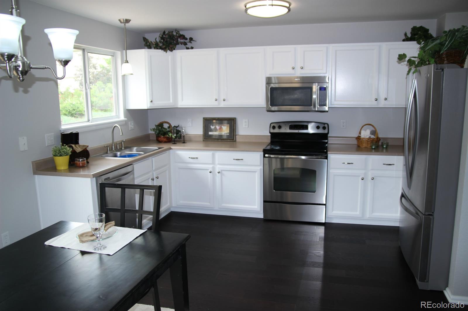 9611 South Castle Ridge Circle Highlands Ranch, CO 80129 - Photo 7 of 25 a kitchen with a stove a sink and a microwave