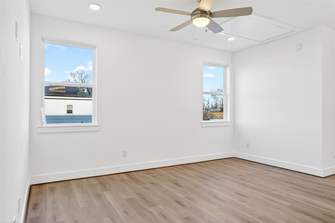 10232 Porto Rico Road Houston, TX 77041 - Photo 28 of 30 an empty room with wooden floor chandelier fan and windows