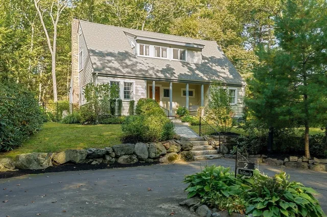 a front view of a house with a garden and yard