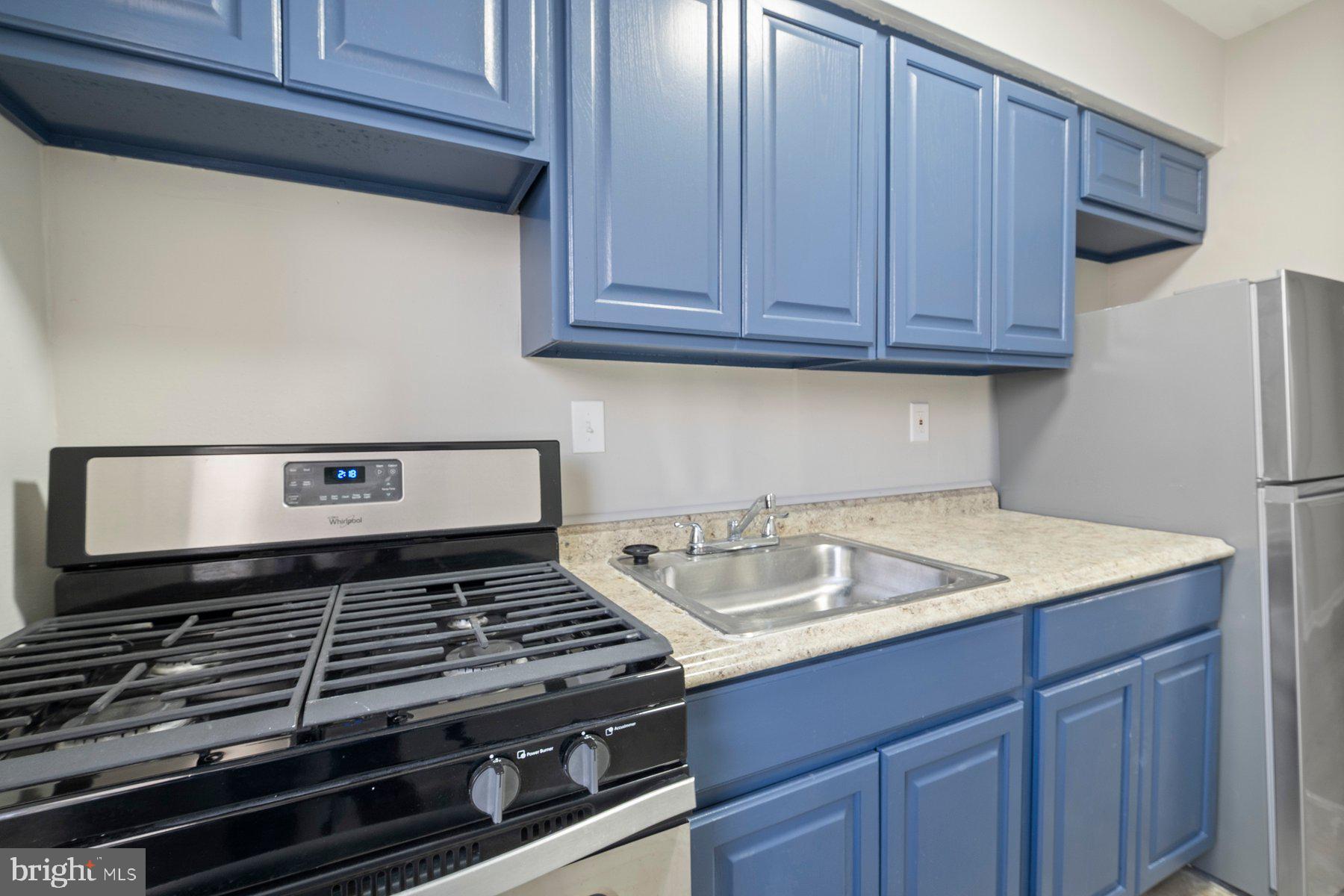 883 Bellevue Street Southeast, Unit 2 Washington, DC 20032 - Photo 11 of 37 a kitchen with wooden cabinets and a stove top oven