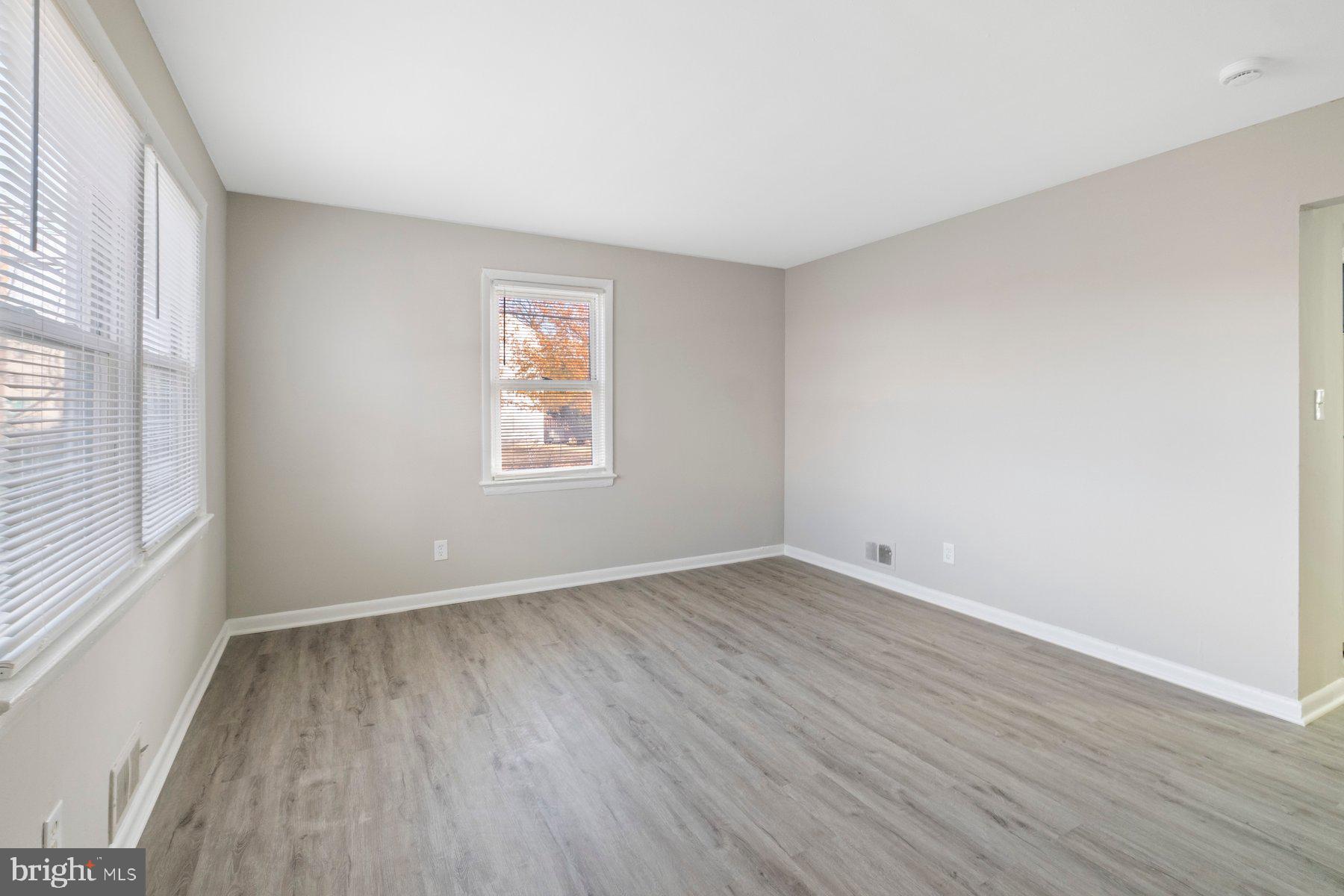 883 Bellevue Street Southeast, Unit 2 Washington, DC 20032 - Photo 20 of 37 an empty room with wooden floor and windows