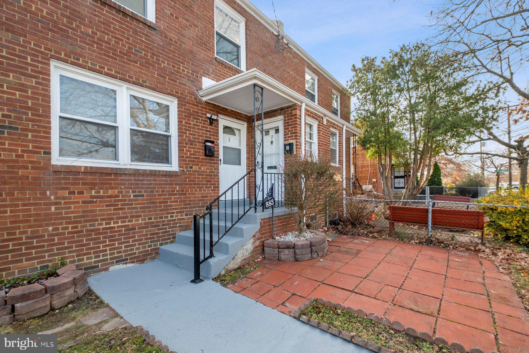 883 Bellevue Street Southeast, Unit 2 Washington, DC 20032 - Photo 2 of 37 a view of a brick house with many windows next to a road
