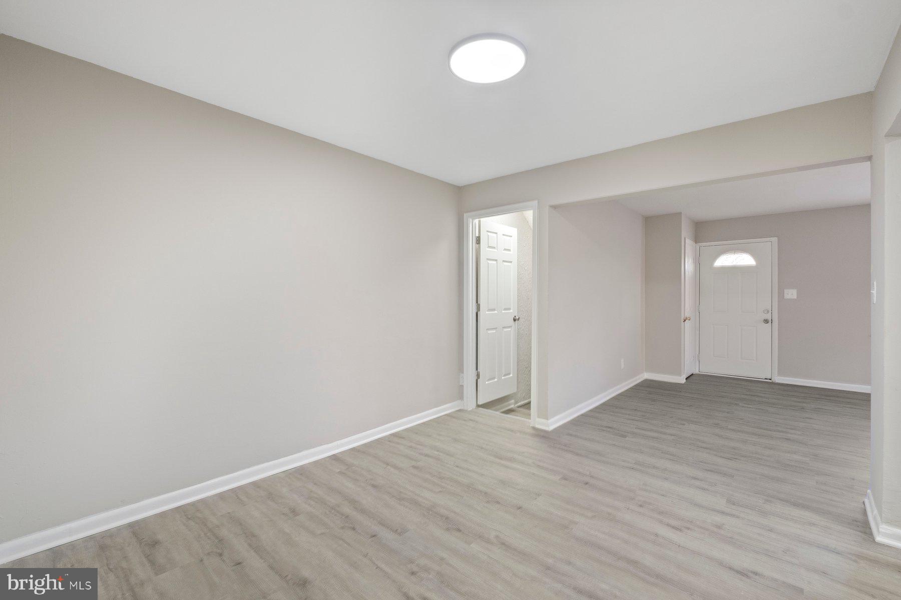 883 Bellevue Street Southeast, Unit 2 Washington, DC 20032 - Photo 24 of 37 an empty room with wooden floor and windows